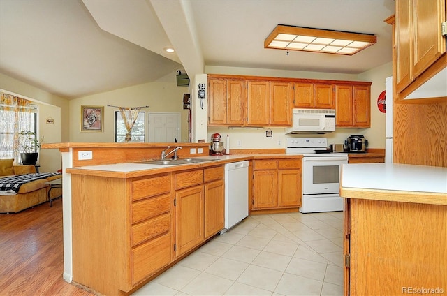 kitchen with a sink, white appliances, light countertops, a peninsula, and lofted ceiling