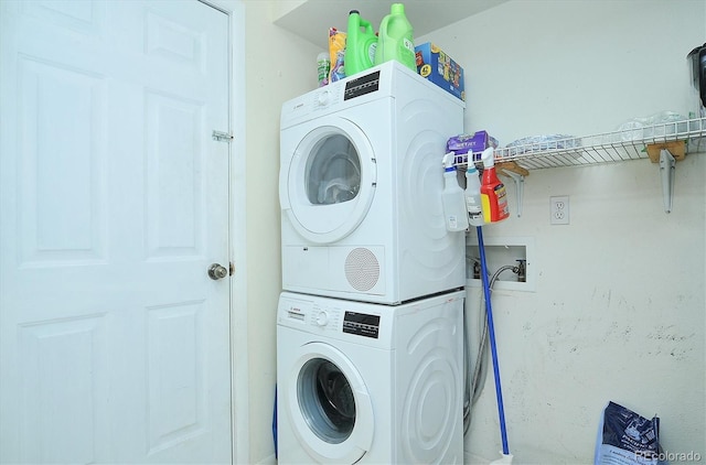 laundry room featuring stacked washer / drying machine and laundry area