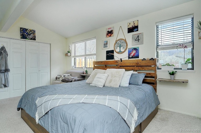 carpeted bedroom featuring a closet, baseboards, and lofted ceiling