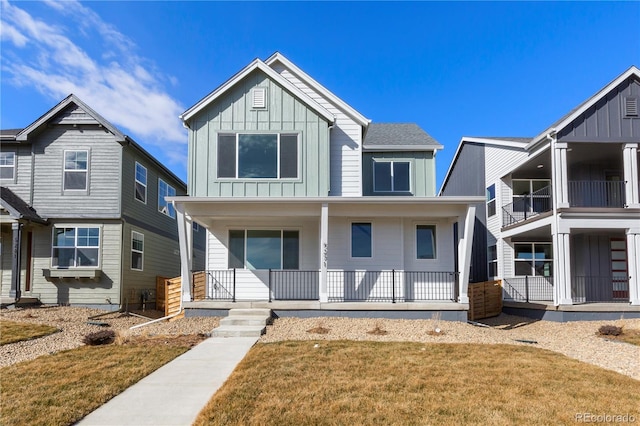 5271 Rendezvous Pkwy, Timnath, CO 80547 - view of front of property with board and batten siding, a porch, and a front yard