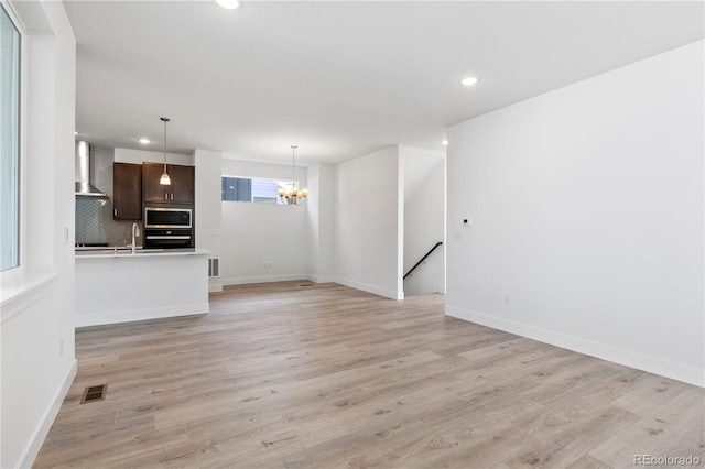 5271 Rendezvous Pkwy, Timnath, CO 80547 - unfurnished living room featuring a chandelier, recessed lighting, light wood finished floors, baseboards, and a sink