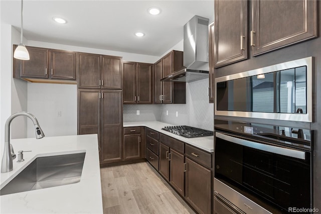 5271 Rendezvous Pkwy, Timnath, CO 80547 - kitchen with appliances with stainless steel finishes, a sink, wall chimney exhaust hood, dark brown cabinetry, and light countertops