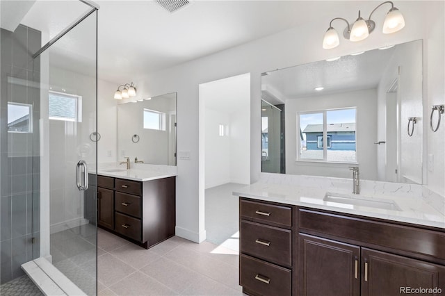 5271 Rendezvous Pkwy, Timnath, CO 80547 - bathroom featuring a shower stall, two vanities, tile patterned floors, and baseboards