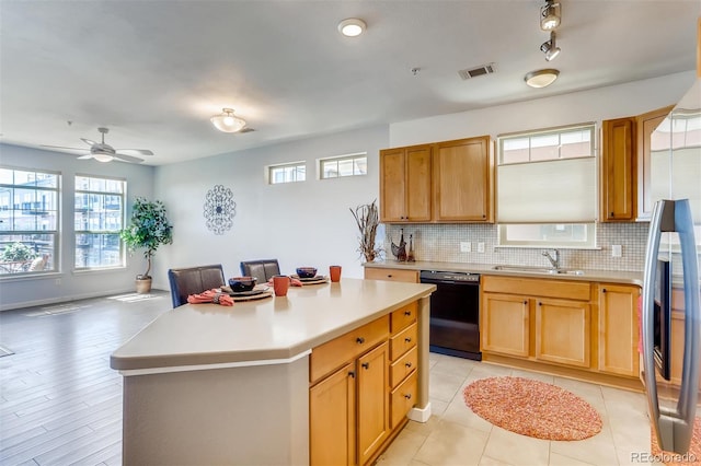 13456 Via Varra Unit 315, Broomfield, CO 80020 - kitchen featuring dishwasher, a sink, light countertops, decorative backsplash, and plenty of natural light
