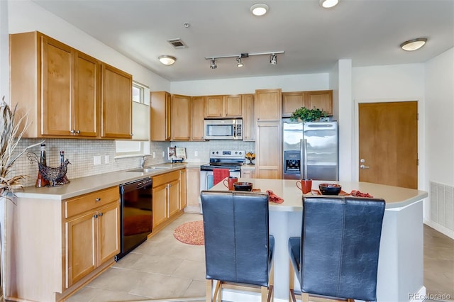 13456 Via Varra Unit 315, Broomfield, CO 80020 - kitchen with appliances with stainless steel finishes, a sink, a kitchen island, tasteful backsplash, and light countertops