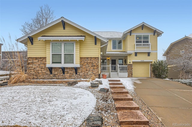 view of front of property with stone siding, concrete driveway, an attached garage, and covered porch