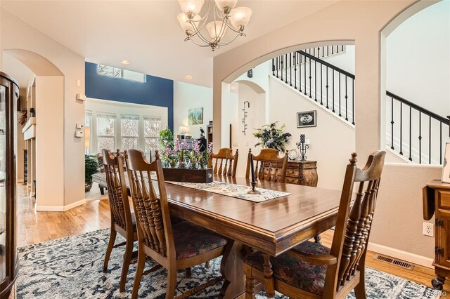 dining area with a chandelier, stairs, light wood-style flooring, baseboards, and recessed lighting