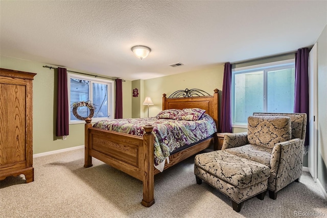 bedroom featuring light carpet, a textured ceiling, and baseboards