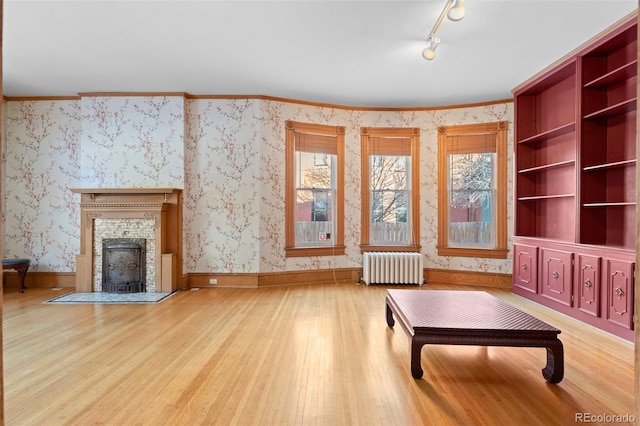 interior space featuring crown molding, radiator, and light hardwood / wood-style flooring