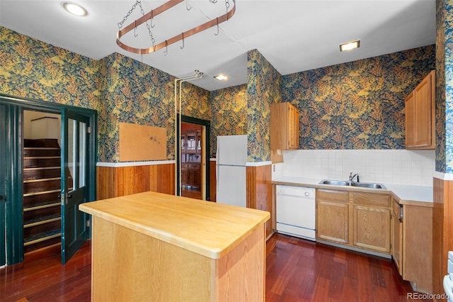 kitchen with dark hardwood / wood-style floors, sink, and white appliances