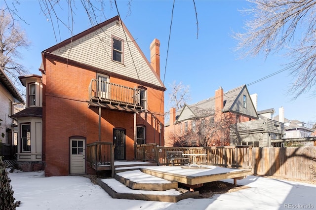 view of snow covered back of property