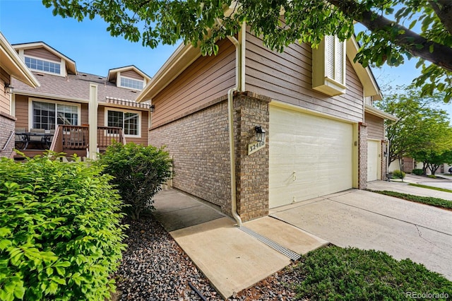 3240 W 114th Cir Unit D, Westminster, CO 80031 - view of property exterior featuring brick siding, driveway, and an attached garage