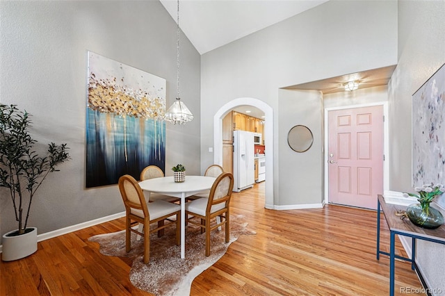 3240 W 114th Cir Unit D, Westminster, CO 80031 - dining room with high vaulted ceiling, arched walkways, light wood-style flooring, baseboards, and a chandelier