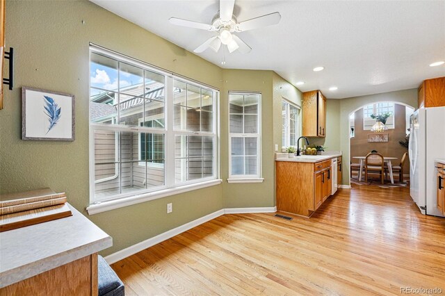 3240 W 114th Cir Unit D, Westminster, CO 80031 - kitchen with light wood-style floors, arched walkways, a sink, light countertops, and recessed lighting