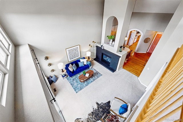 3240 W 114th Cir Unit D, Westminster, CO 80031 - carpeted living room with a glass covered fireplace, arched walkways, and wood finished floors