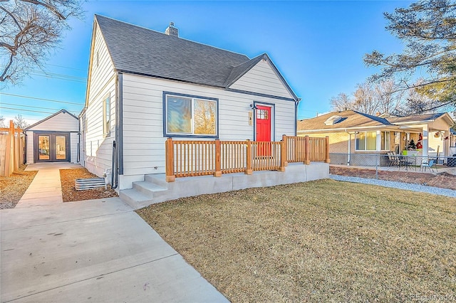 view of front of home featuring a front lawn, french doors, and covered porch