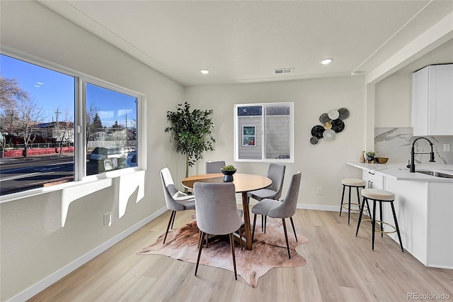 dining space with sink and light hardwood / wood-style flooring