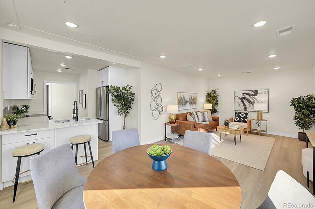 dining space with sink and light hardwood / wood-style flooring