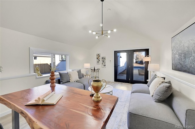 living room featuring light hardwood / wood-style floors, an inviting chandelier, and vaulted ceiling