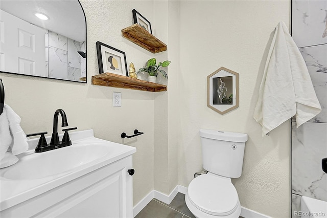 bathroom featuring toilet, vanity, and tile patterned flooring