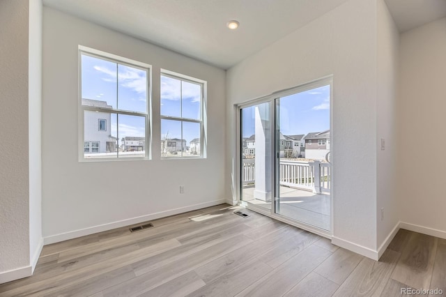 empty room with visible vents, baseboards, and light wood-style floors