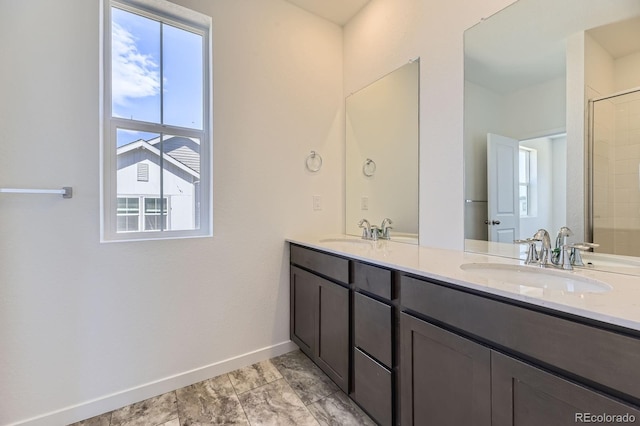 bathroom featuring baseboards, a sink, and double vanity
