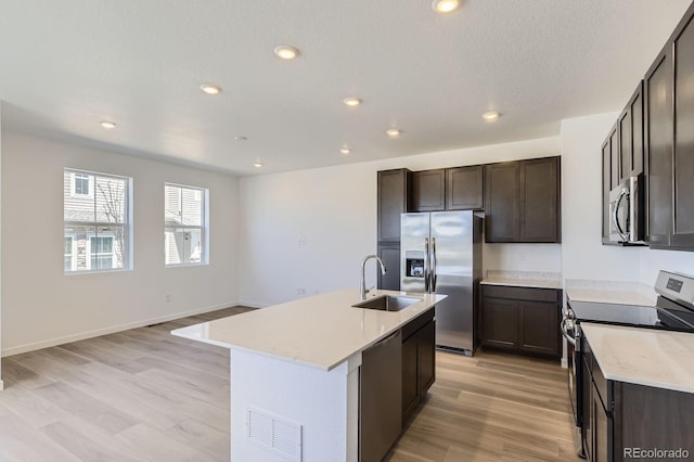 kitchen featuring dark brown cabinetry, appliances with stainless steel finishes, a sink, and visible vents