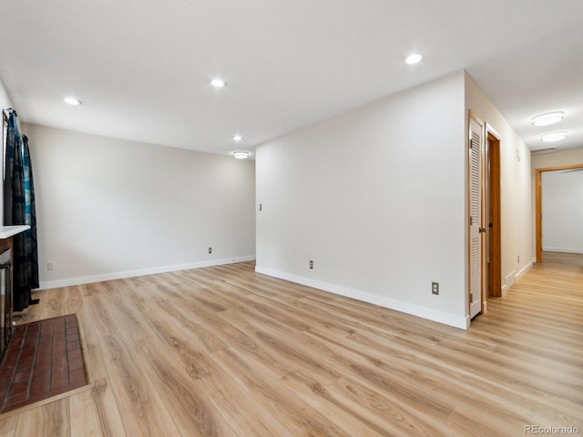 unfurnished living room with a fireplace and light wood-type flooring