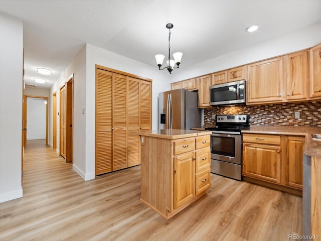 kitchen with stainless steel appliances, light hardwood / wood-style floors, a chandelier, tasteful backsplash, and a kitchen island