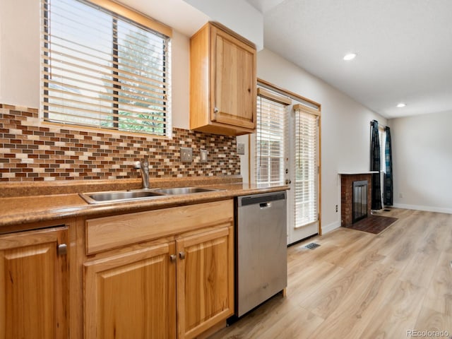 kitchen with sink, light hardwood / wood-style floors, a healthy amount of sunlight, and stainless steel dishwasher