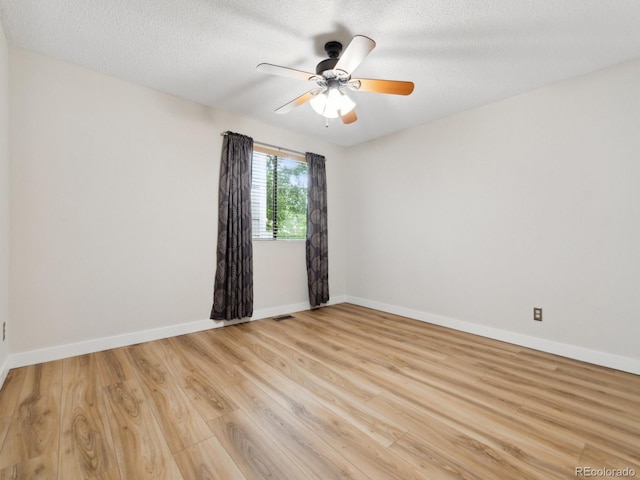 spare room featuring light wood-type flooring, ceiling fan, and a textured ceiling