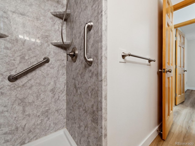 bathroom featuring hardwood / wood-style flooring and a tile shower