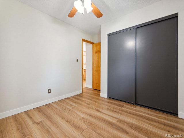 unfurnished bedroom featuring light wood-type flooring, a closet, and ceiling fan