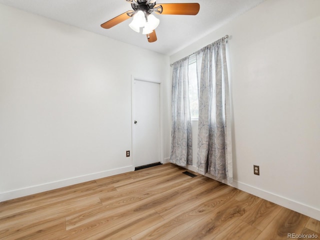 empty room with ceiling fan and light hardwood / wood-style floors