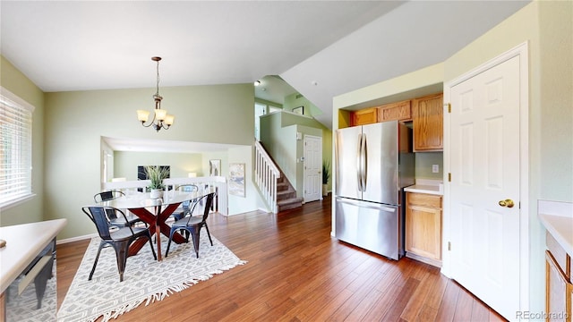 4164 E 135th Pl, Thornton, CO 80241 - dining space featuring stairs, wood finished floors, lofted ceiling, and a chandelier