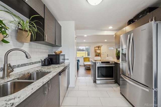 2870 Pontiac St, Denver, CO 80207 - kitchen with stainless steel appliances, a sink, tasteful backsplash, light tile patterned floors, and recessed lighting