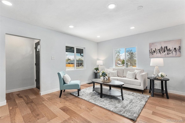 living room featuring baseboards, light wood-style floors, and recessed lighting