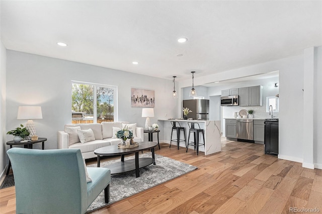 living room featuring light wood-style floors, recessed lighting, and baseboards
