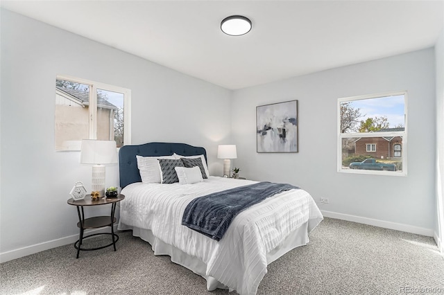 bedroom featuring multiple windows, baseboards, and carpet