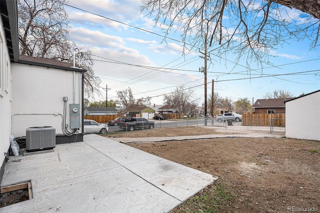 view of yard featuring central AC and fence