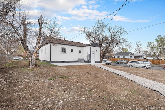 view of front of property featuring fence and central AC unit