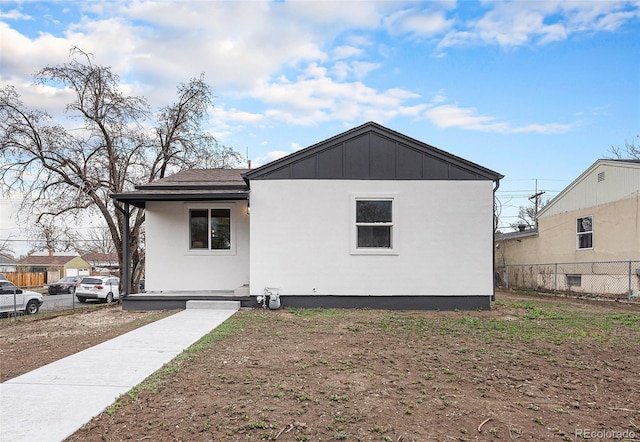 rear view of house with fence and board and batten siding