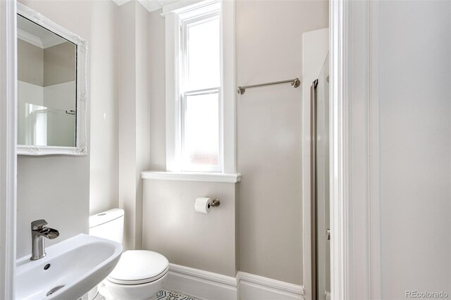 bathroom with toilet, sink, and an enclosed shower