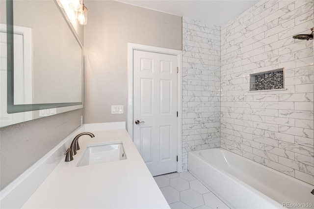 bathroom with tiled shower / bath combo, vanity, and tile patterned flooring