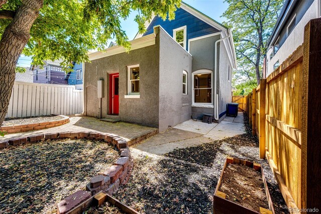 view of front facade with a fenced backyard, stucco siding, and a patio area