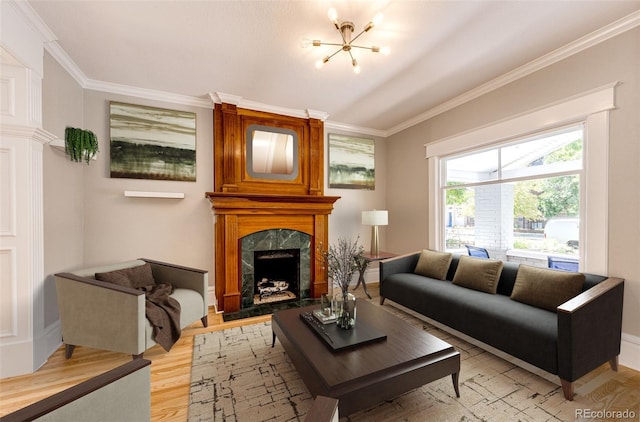 living room featuring a fireplace, light wood-type flooring, crown molding, and a notable chandelier