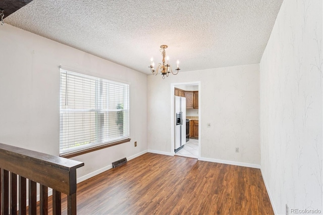 7713 E Jamison Dr, Centennial, CO 80112 - empty room with a chandelier, wood finished floors, and a textured ceiling