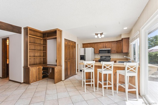 7713 E Jamison Dr, Centennial, CO 80112 - kitchen featuring stainless steel microwave, range, white refrigerator with ice dispenser, a peninsula, and light countertops