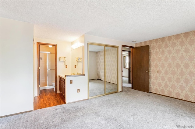 7713 E Jamison Dr, Centennial, CO 80112 - unfurnished bedroom featuring carpet flooring, a textured ceiling, a closet, and ensuite bathroom