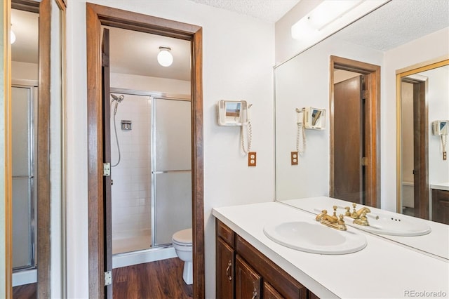 7713 E Jamison Dr, Centennial, CO 80112 - full bath featuring a textured ceiling, a shower stall, vanity, and wood finished floors